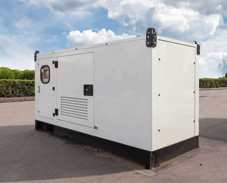 Large white generator on a paved area, set against a cloudy blue sky and green foliage. The scene conveys functionality and preparedness.